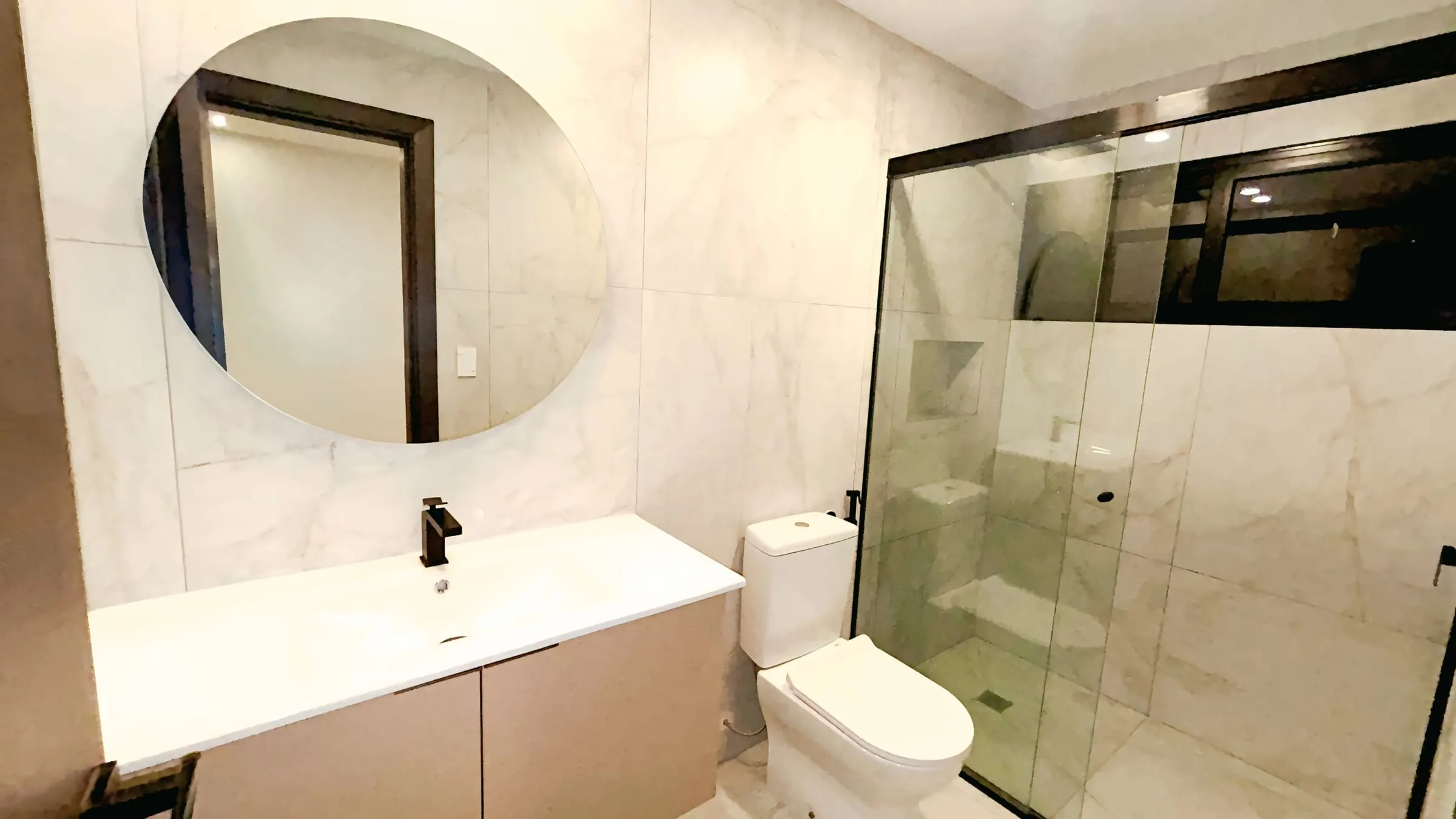 Baño en mármol con ducha de vidrio