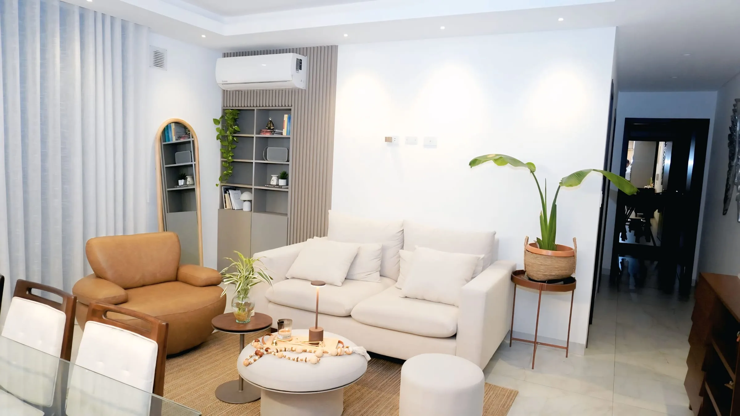 Salón con sofá blanco y sillón cuero